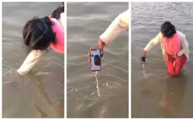 വീഡിയോ കോളിലെത്തിയ ഭർത്താവിനെ ഗംഗയിൽ സ്നാനം നടത്തി യുവതി; ഫോൺ മുങ്ങിപ്പോയിരുന്നെങ്കിൽ തൽക്ഷണം മോക്ഷം കിട്ടിയേനെയെന്ന് കമൻ്റ് വീഡിയോ